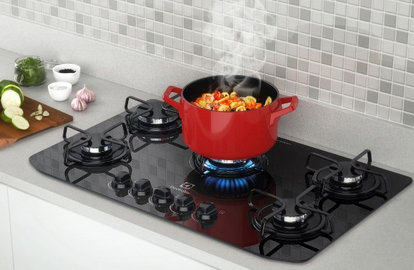 Cooktop de 5 bocas com panela no fogo.